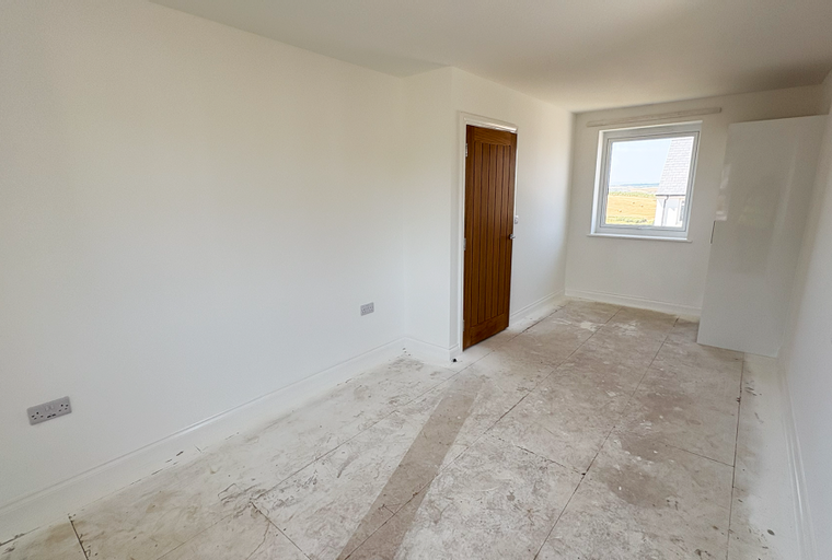 A room with a wooden door, a window, and a closet.