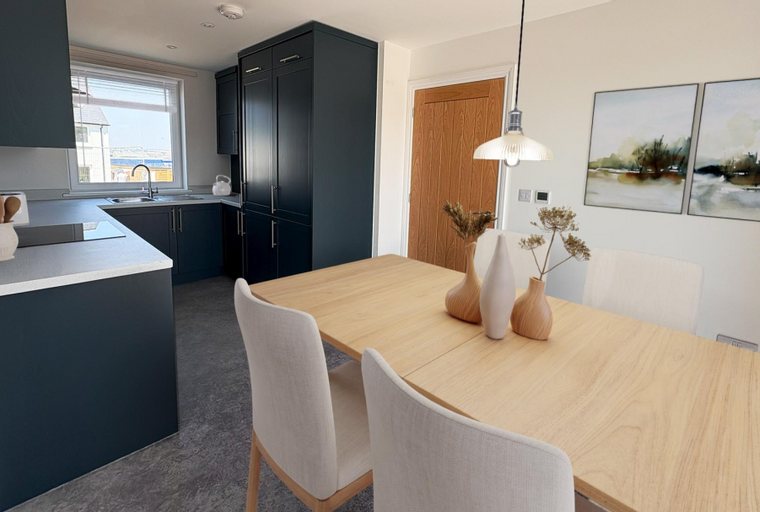 A kitchen and dining area with dark cabinets, a wooden table, and chairs.