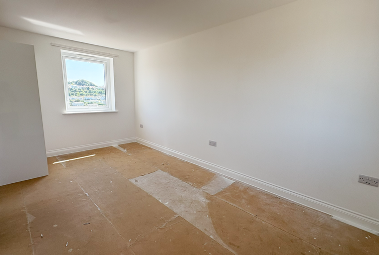 A bedroom with a window and a door.
