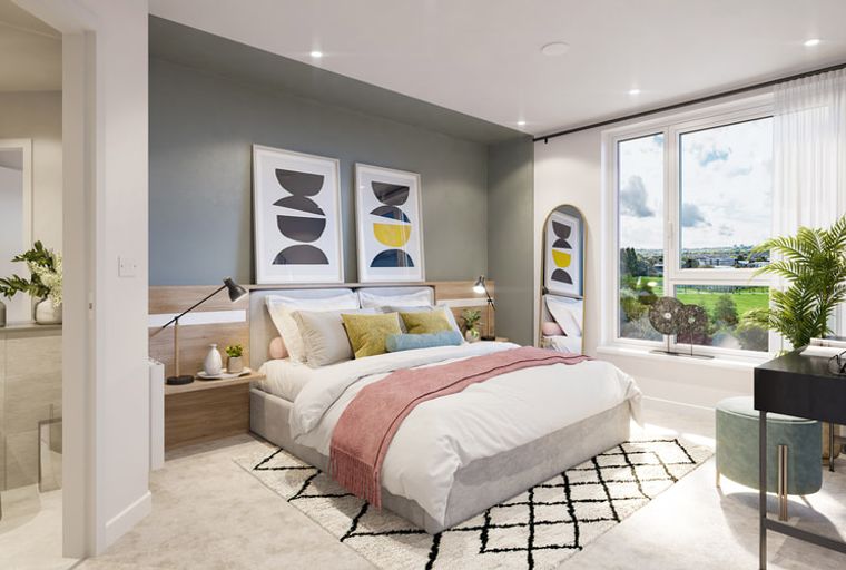 A bedroom with a bed, bedside tables, artwork, and a large window.