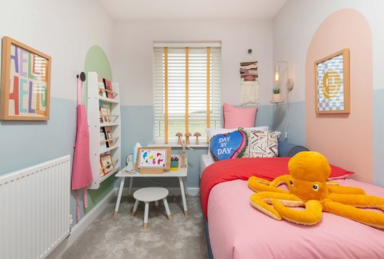 A child's bedroom with a bed, a desk, and a bookshelf.