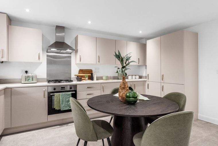 A kitchen with a dining table and chairs.