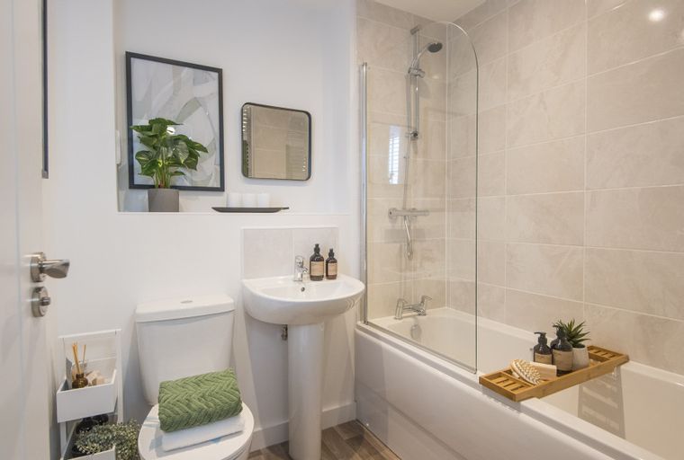 A bathroom with a toilet, sink, and bathtub with a shower.