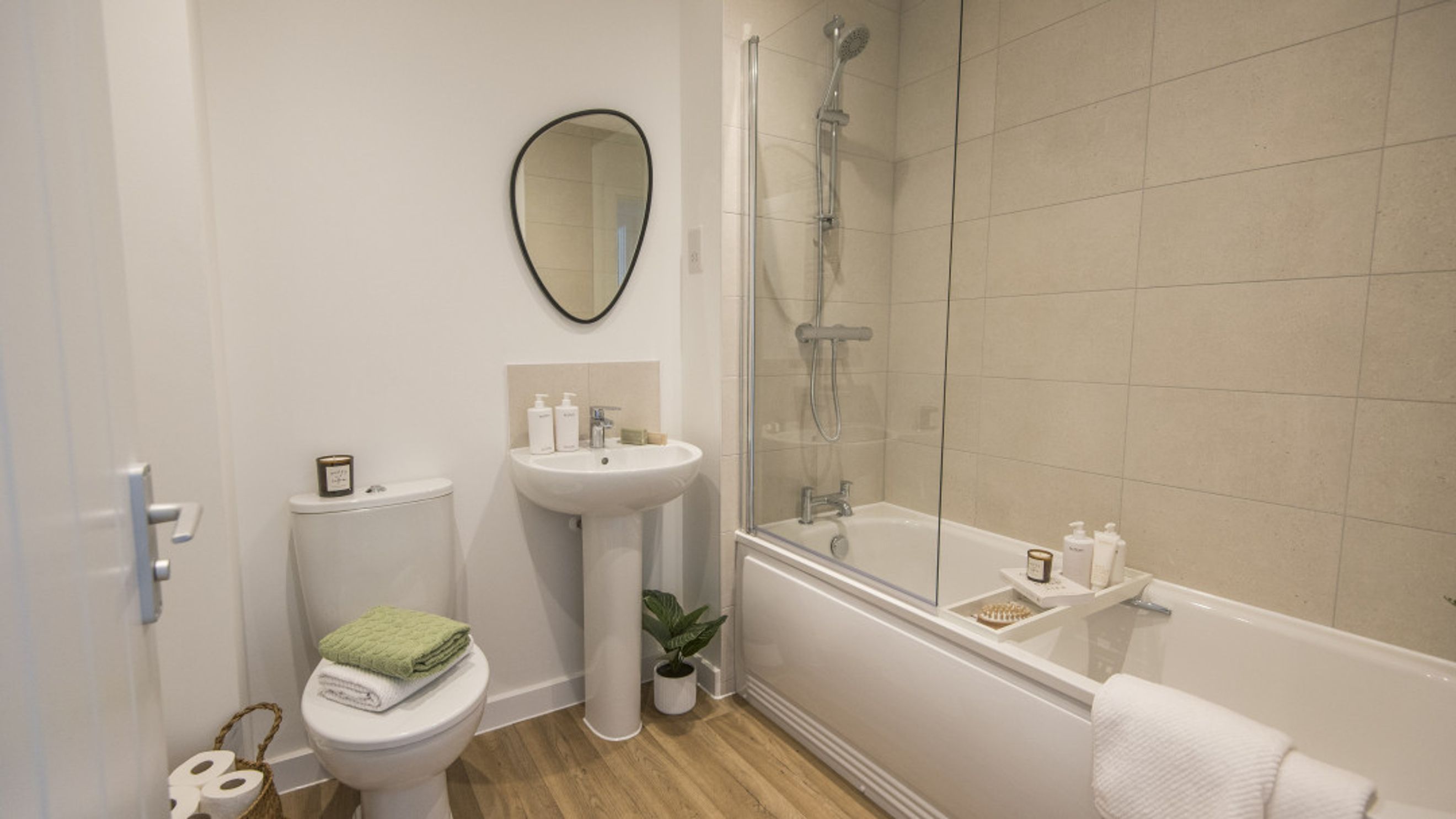 A bathroom with a toilet, sink, and bathtub with a shower.