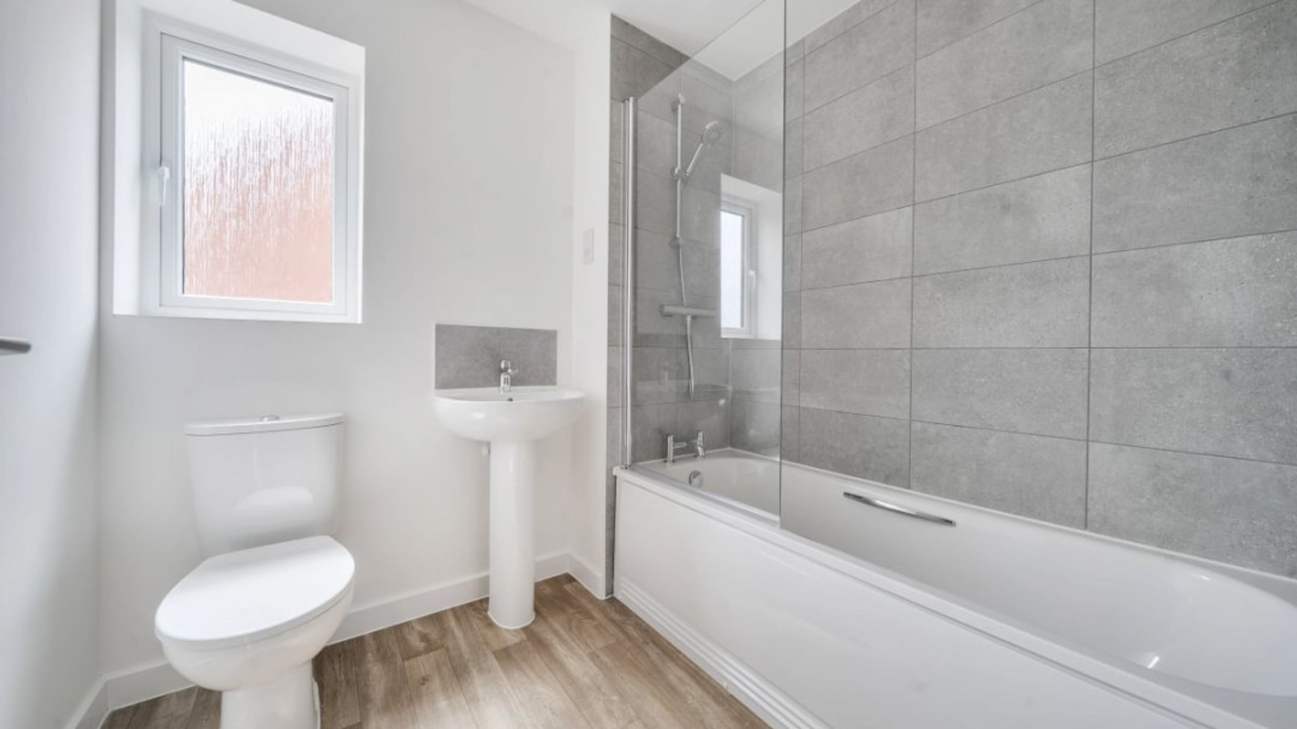 A bathroom with a toilet, sink, and bathtub.