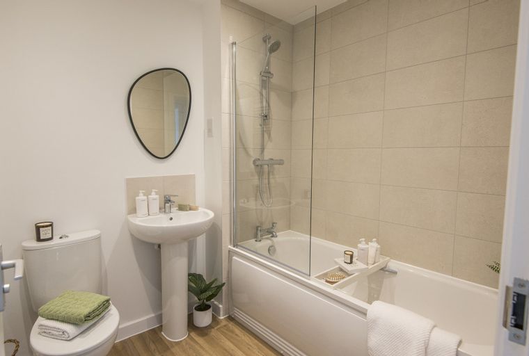 A bathroom with a toilet, sink, and bathtub with a shower.