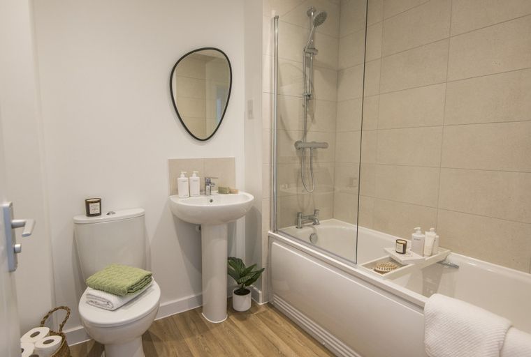 A bathroom with a toilet, sink, and bathtub with a shower.