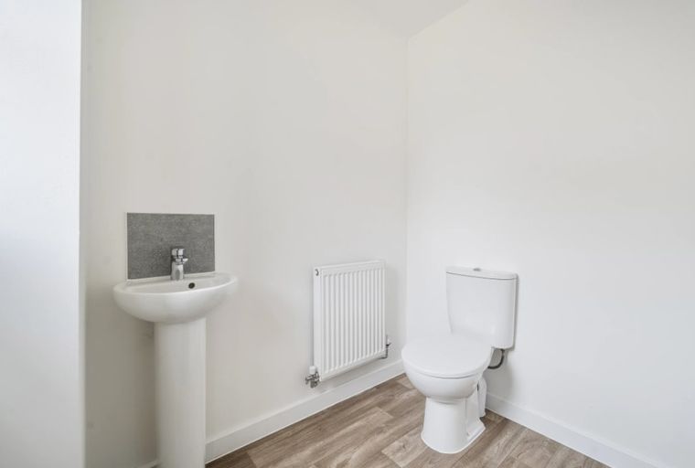 A bathroom with a sink, a radiator, and a toilet.