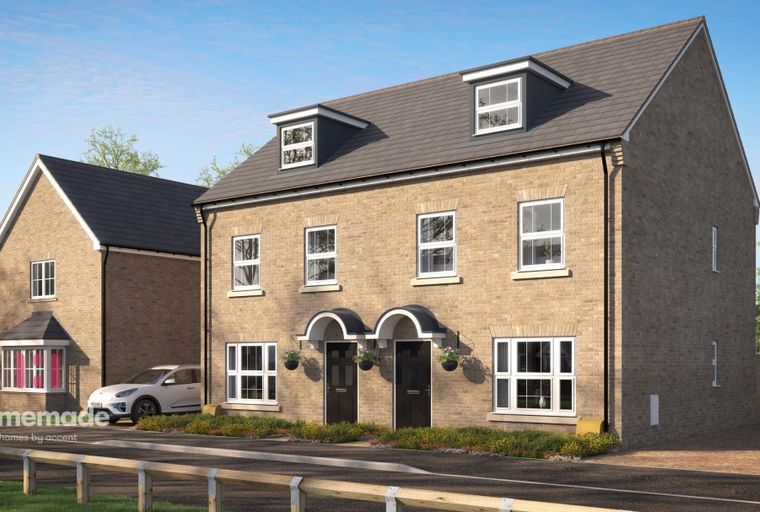 A row of modern brick townhouses with dormer windows and arched doorways.