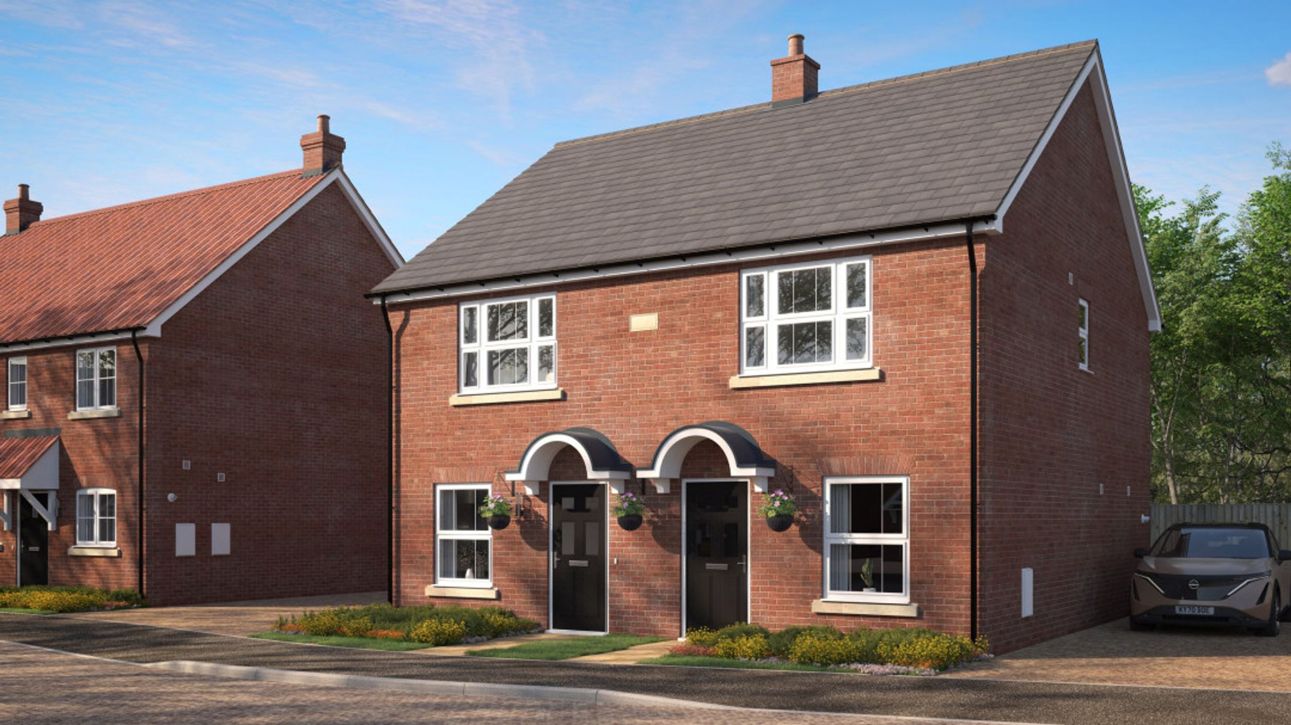 A pair of red brick semi-detached houses with grey roofs and arched doorways.