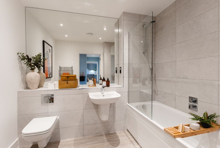 A modern bathroom with a toilet, sink, and bathtub.