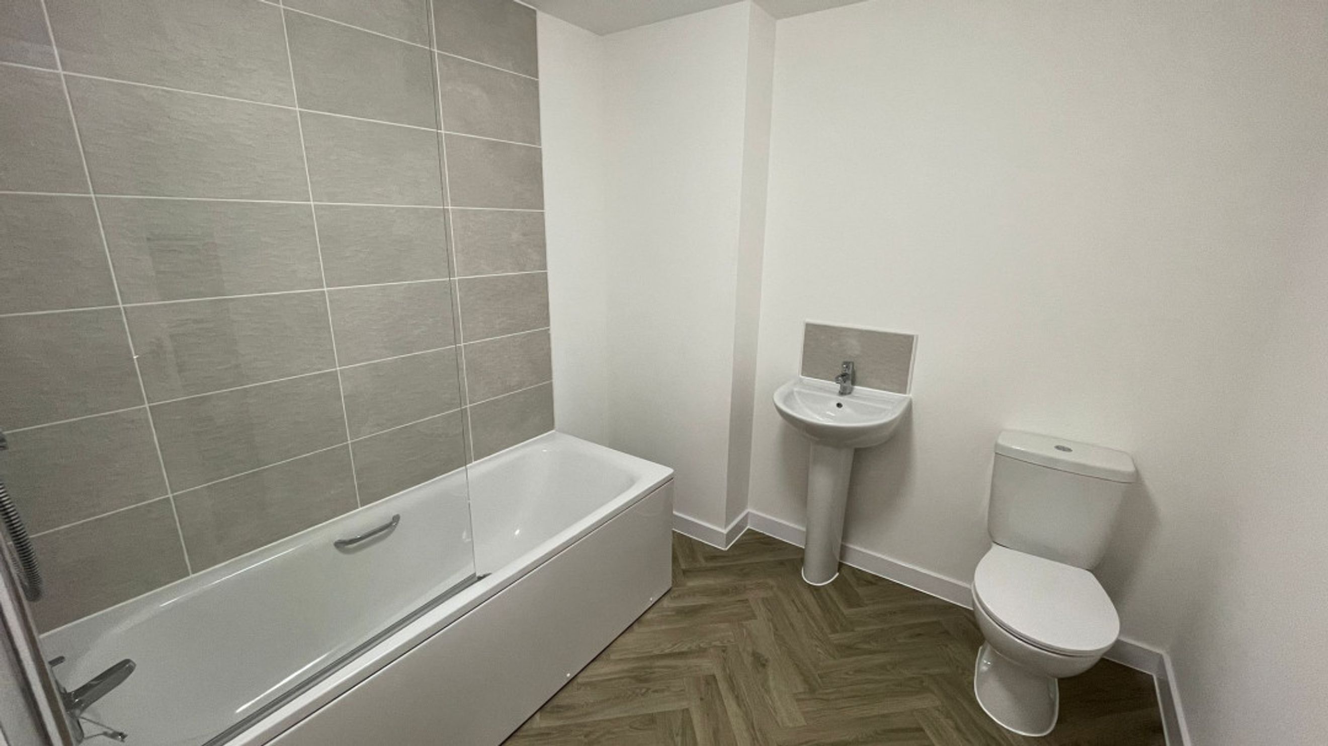 A bathroom with a bathtub, sink, and toilet.