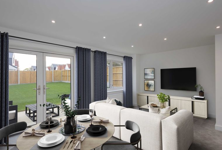 A dining area and living room with French doors opening to a garden.