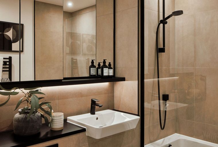 A bathroom with a sink, a mirror, and a shower.