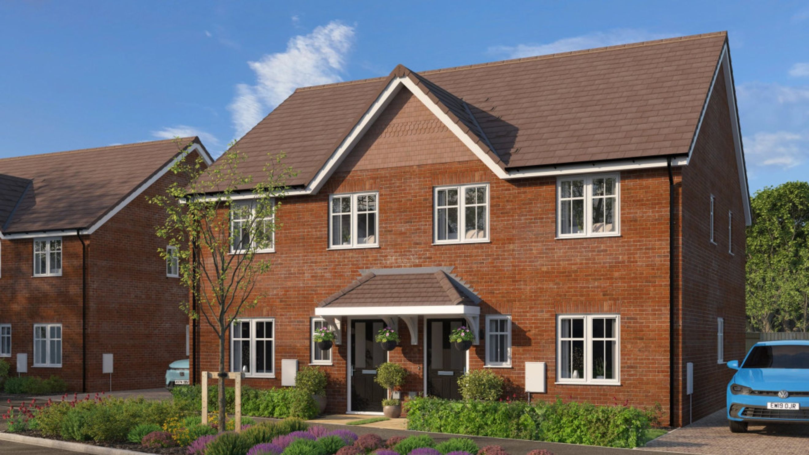 A brick-built semi-detached house with white-framed windows and a brown tiled roof.