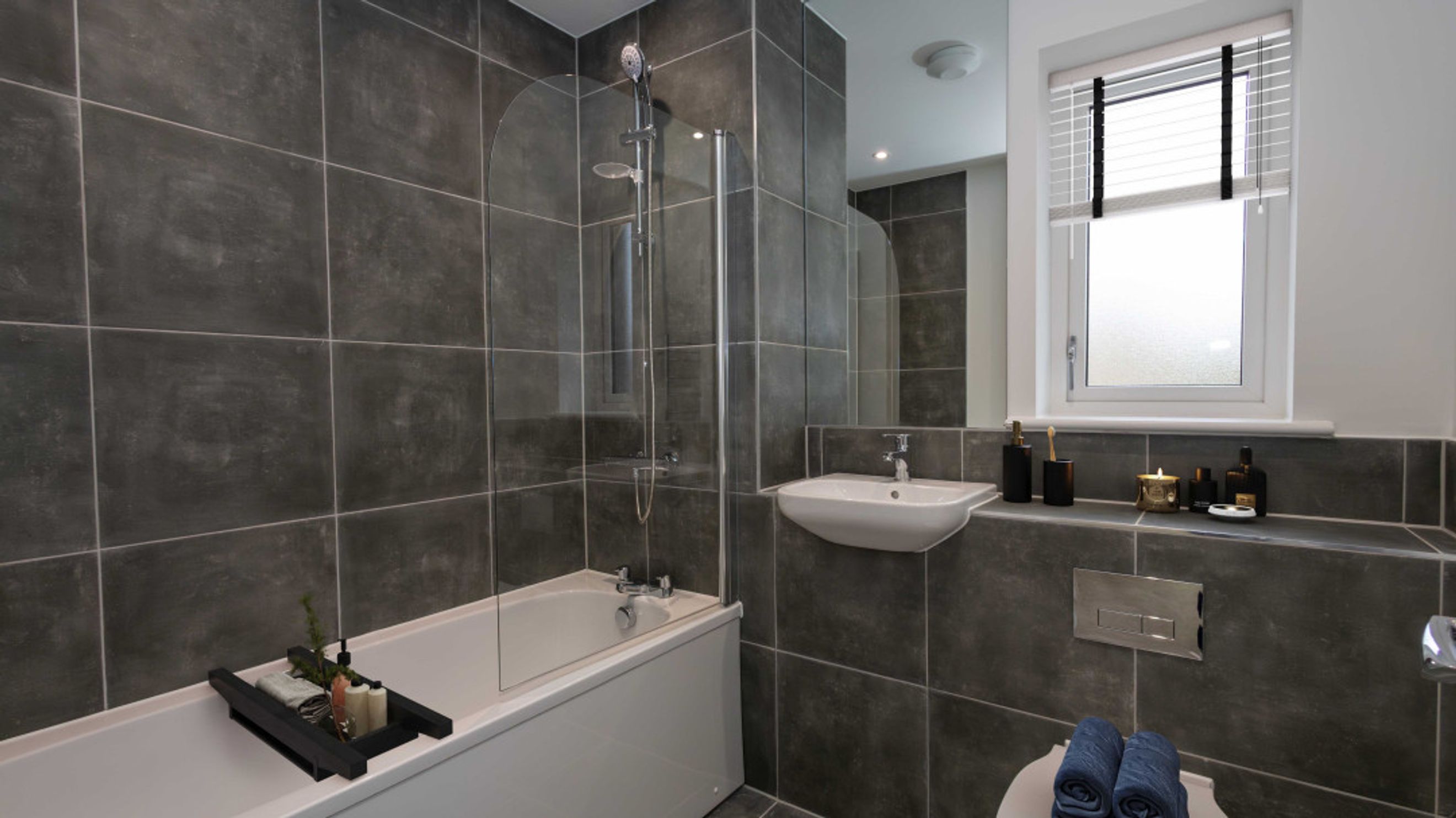 A bathroom with a bathtub, shower, sink, and toilet.