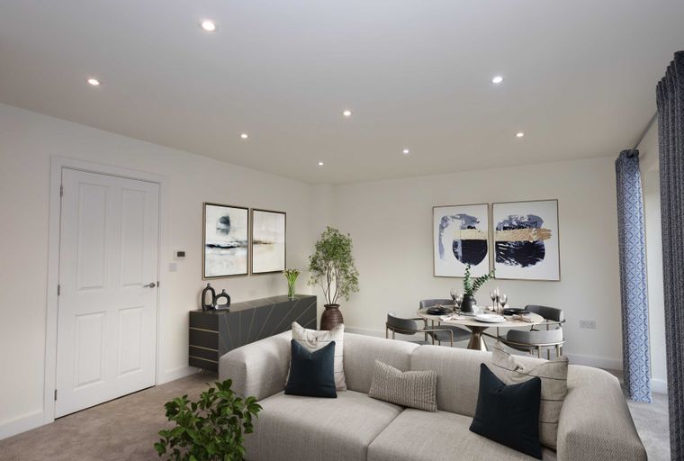 A living and dining room with a sectional sofa, dining table, and abstract art.