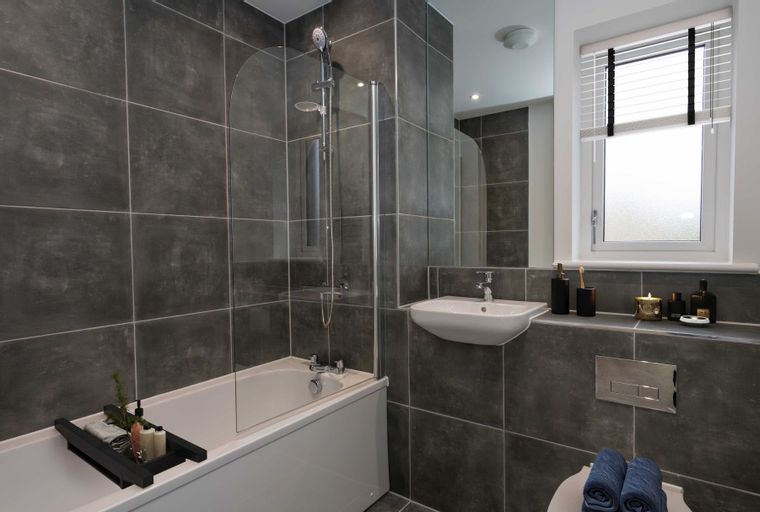 A bathroom with a bathtub, shower, sink, and toilet.