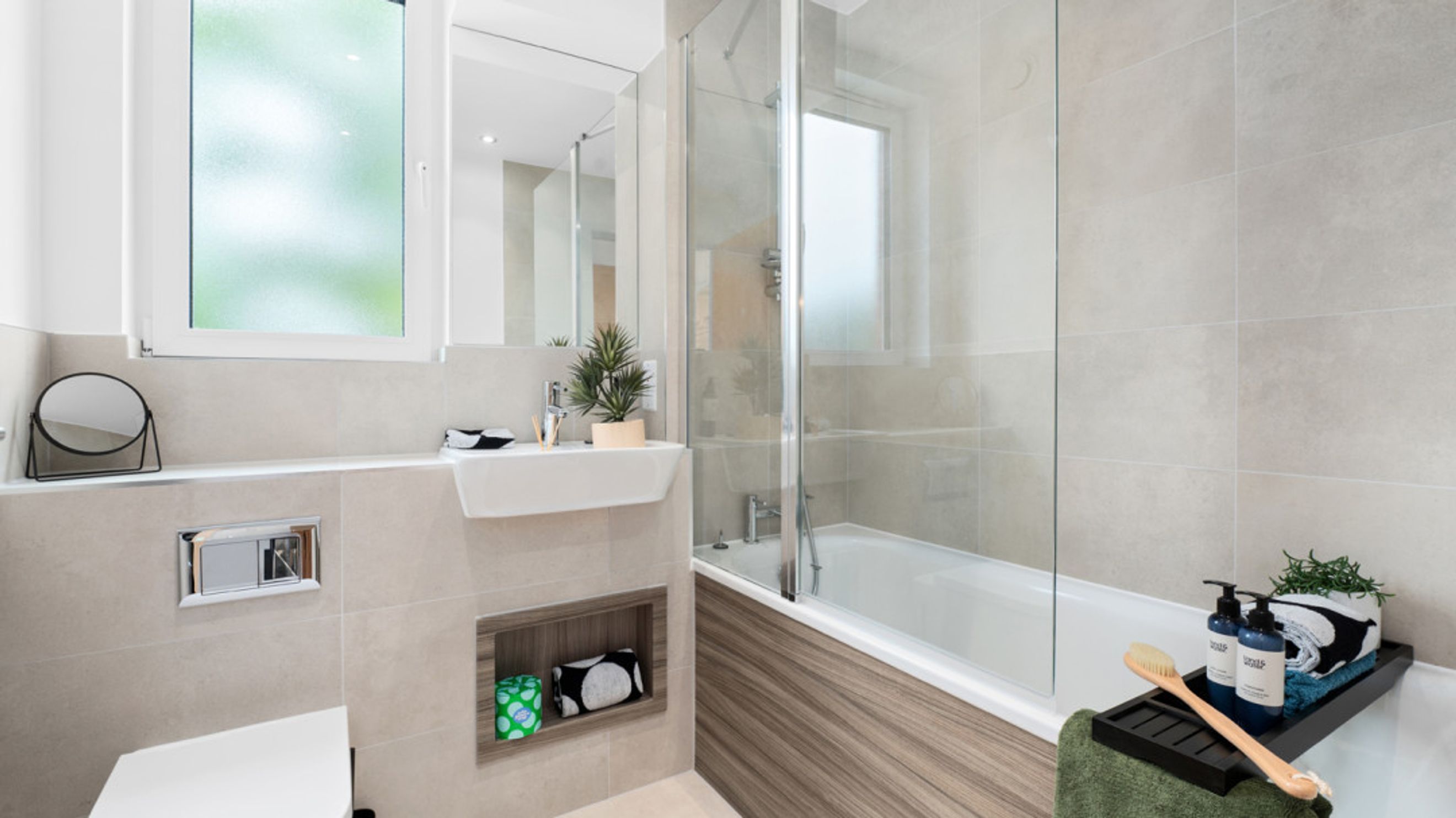 A modern bathroom with a sink, toilet, and bathtub.