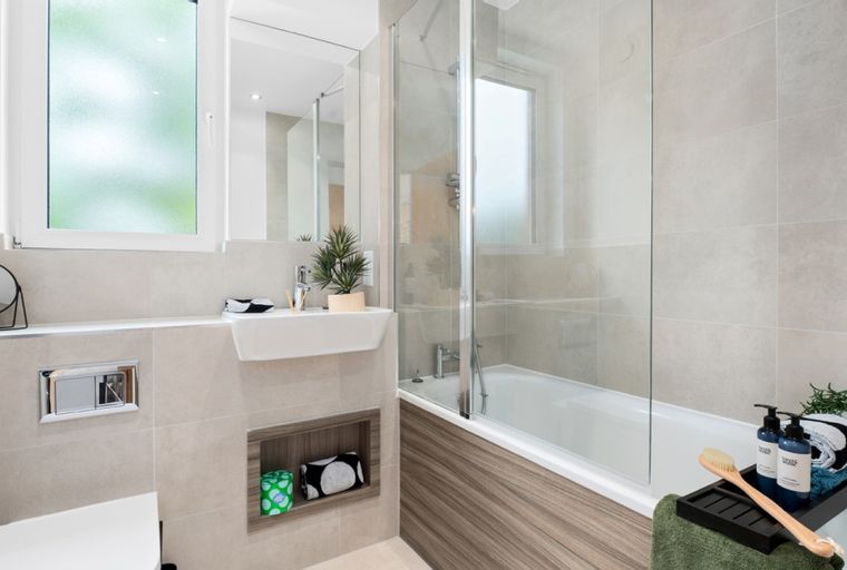 A bathroom with a sink, bathtub, and shower enclosure.