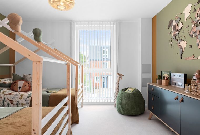 A children's bedroom with two house-frame beds, animal-themed bedding, and a world map mural.