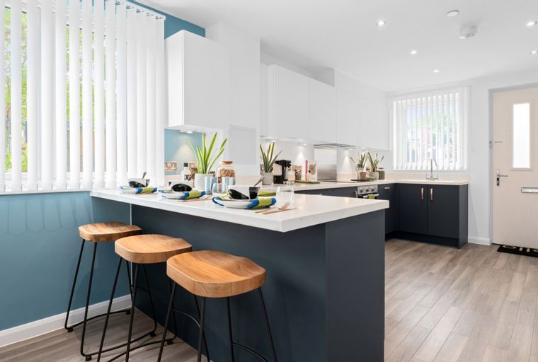 A modern kitchen with an island, bar stools, and dark cabinets.