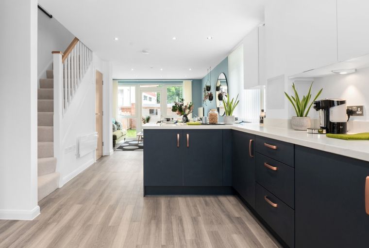 A modern kitchen and living area with a staircase.