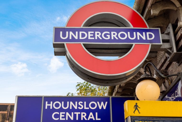 A London Underground sign for Hounslow Central station against a blue sky.