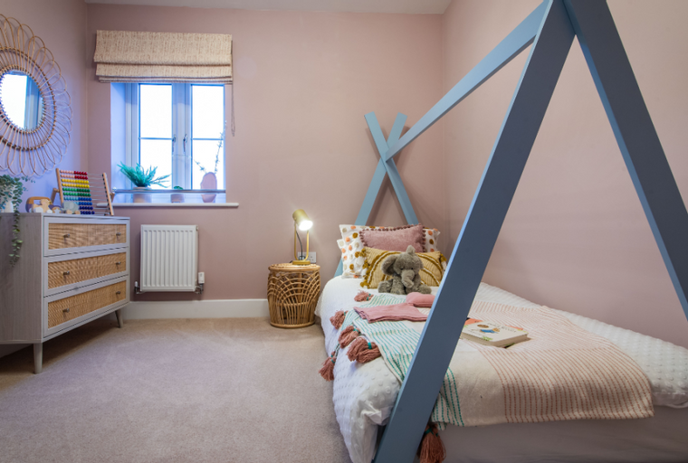 A child's bedroom with a bed, dresser, and mirror.