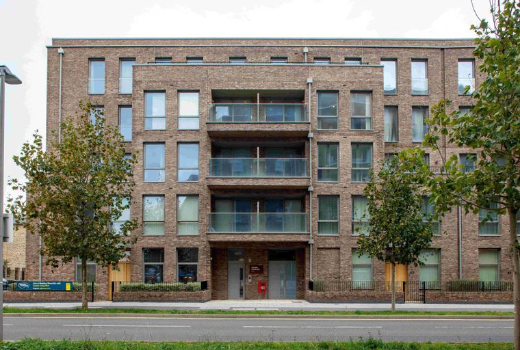 A brick apartment building with multiple windows and balconies.