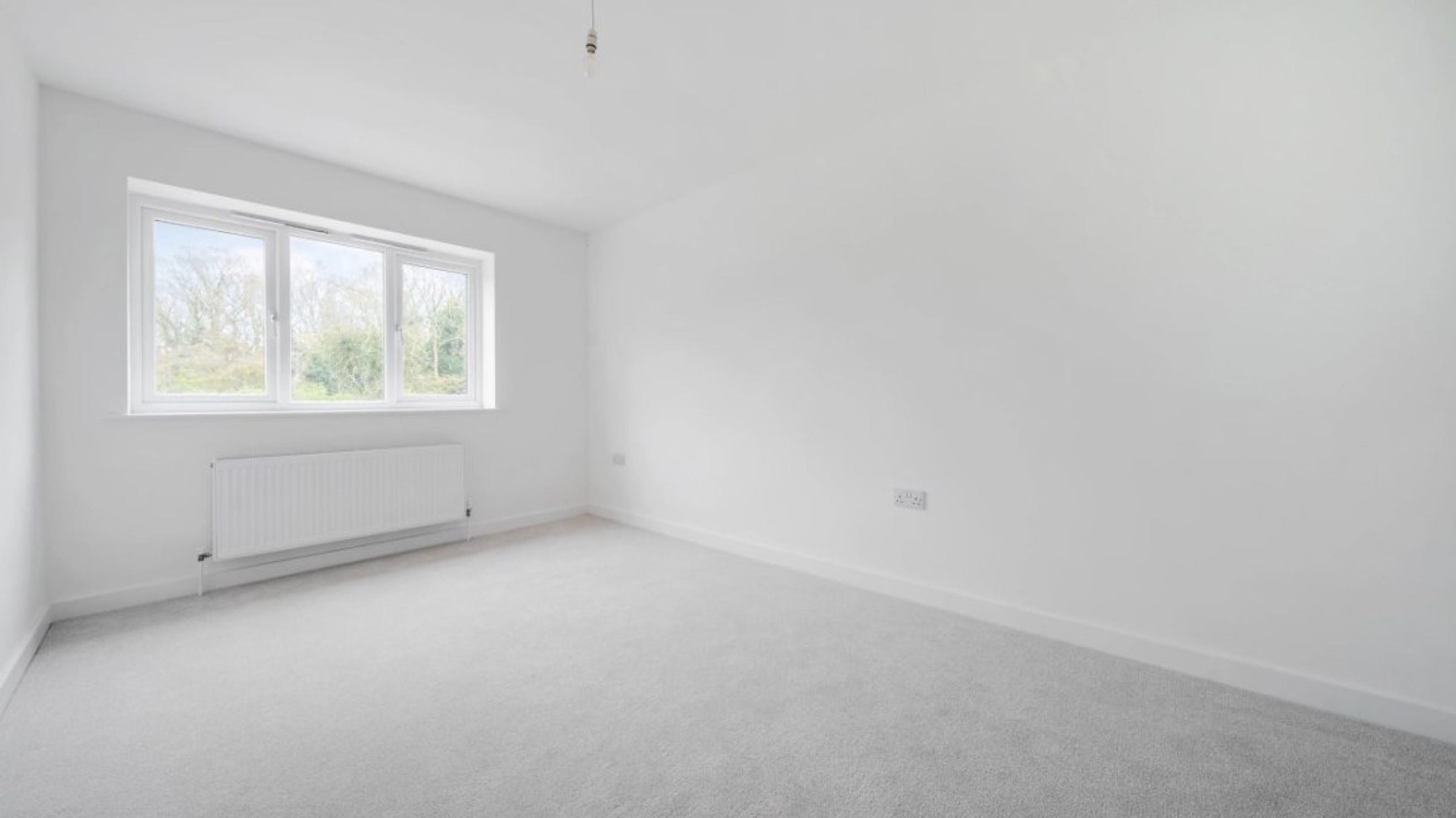 A bedroom with a window and a radiator.