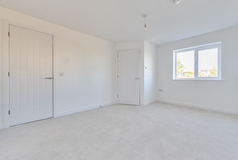 A bedroom with two doors and a window.
