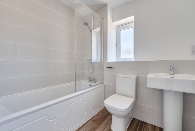 A bathroom with a bathtub, toilet, and sink.