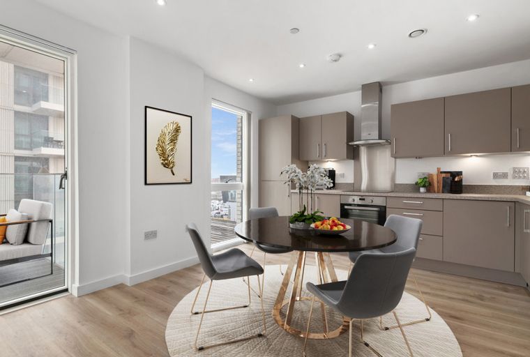 A dining area and kitchen with a round table, chairs, and modern cabinetry.