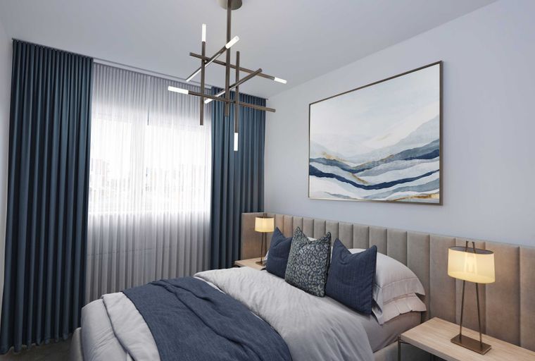 A bedroom with a bed, bedside tables, curtains, and a chandelier.