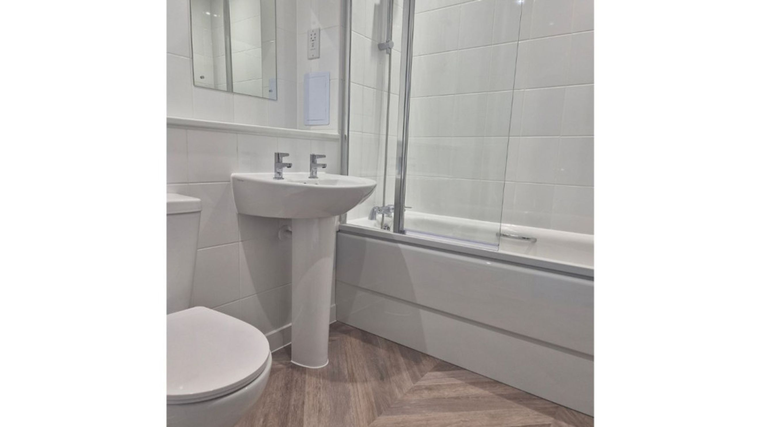 A bathroom with a toilet, sink, and bathtub.