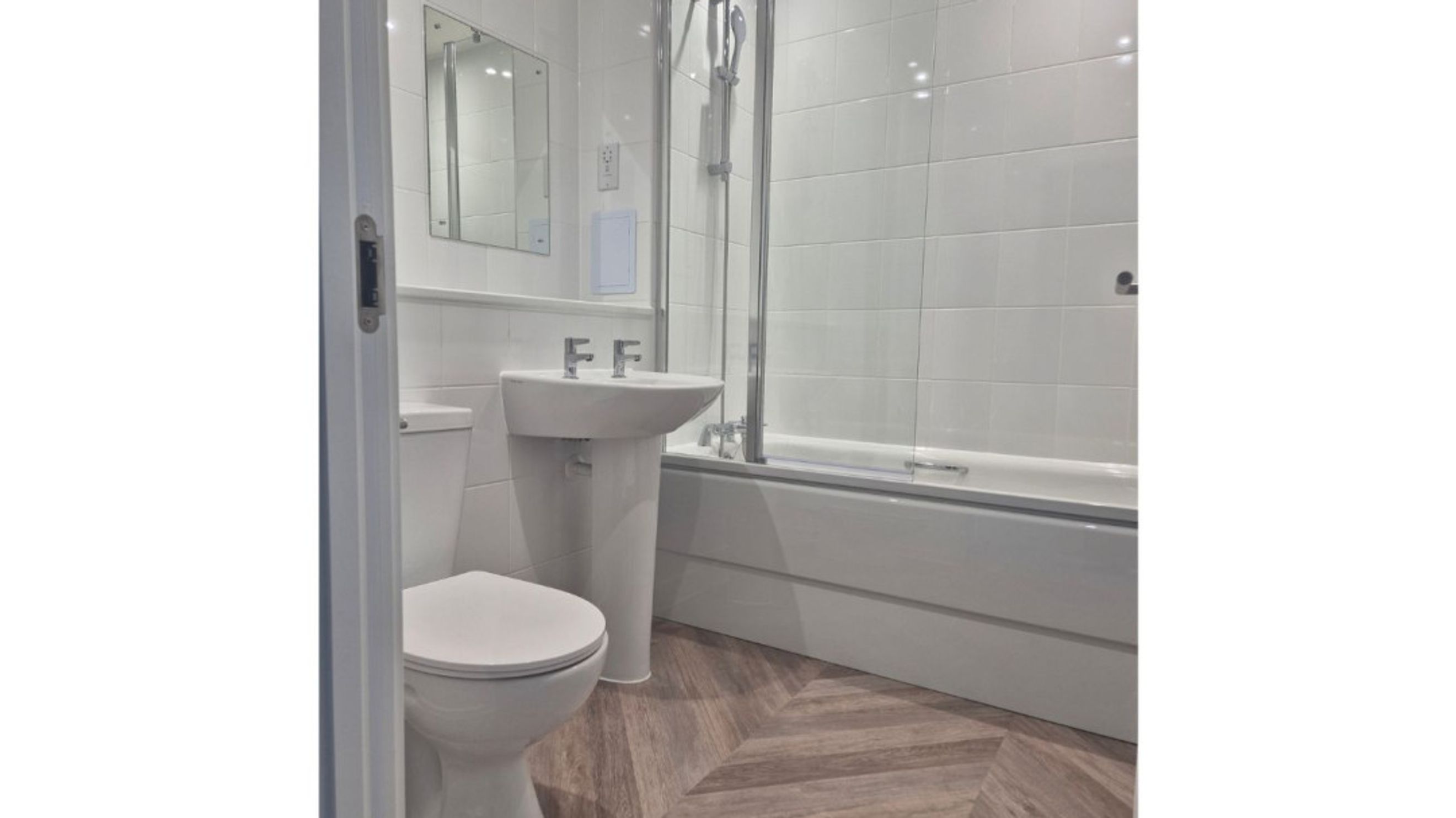 A bathroom with a toilet, sink, and bathtub.