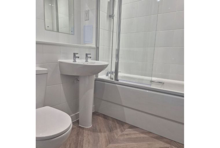 A bathroom with a toilet, sink, and bathtub.
