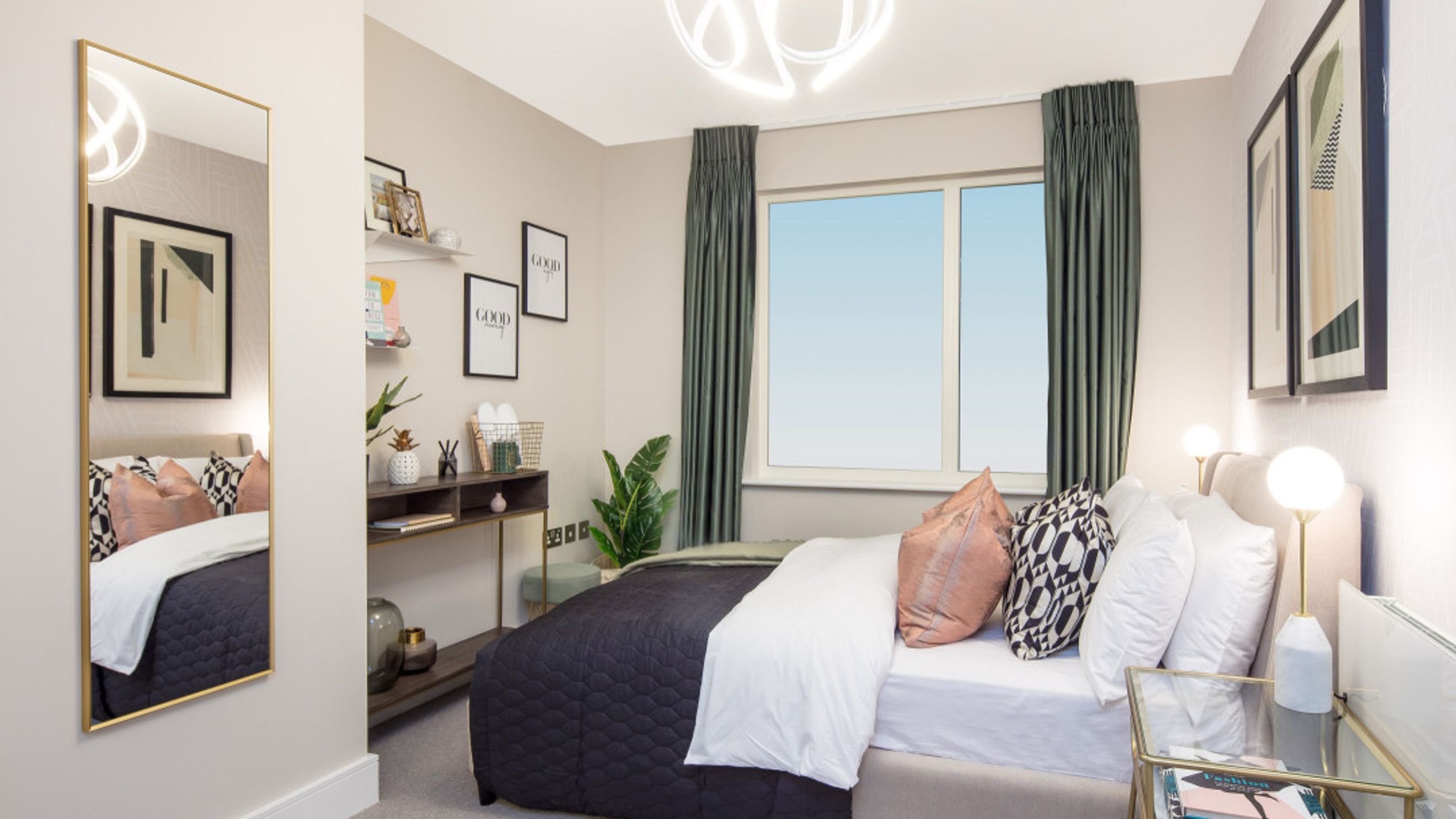 A bedroom with a bed, pillows, a mirror, and artwork.
