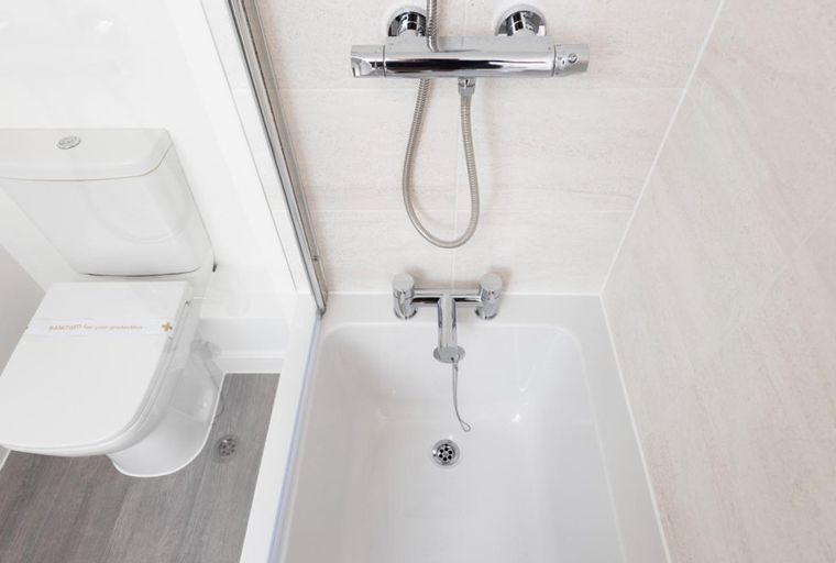 A toilet and a bathtub with a shower head in a bathroom.