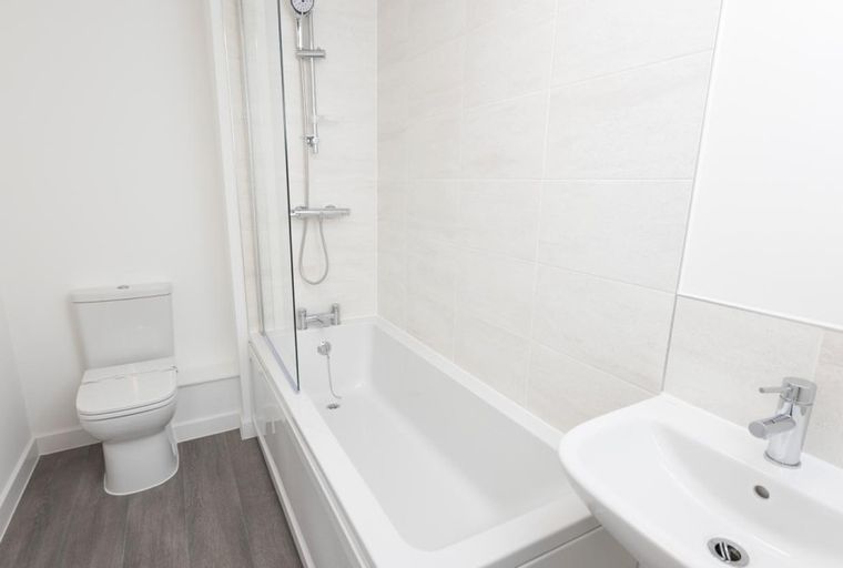 A bathroom with a bathtub, toilet, and sink.
