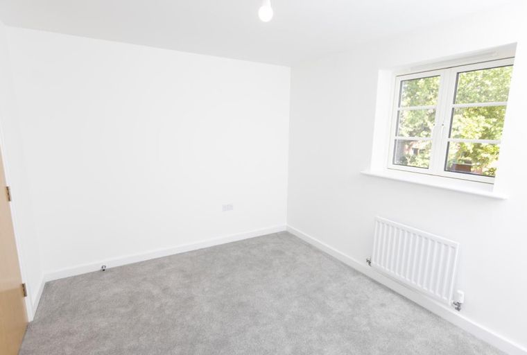A room with a door, window, and radiator.