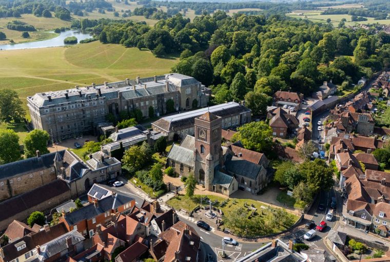 An aerial view of a large estate with a manor house, a church, and a village.