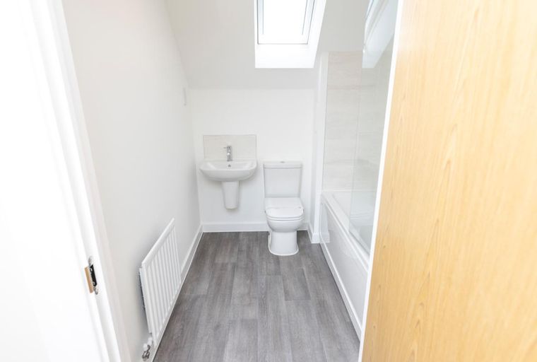 A bathroom with a sink, toilet, and bathtub.