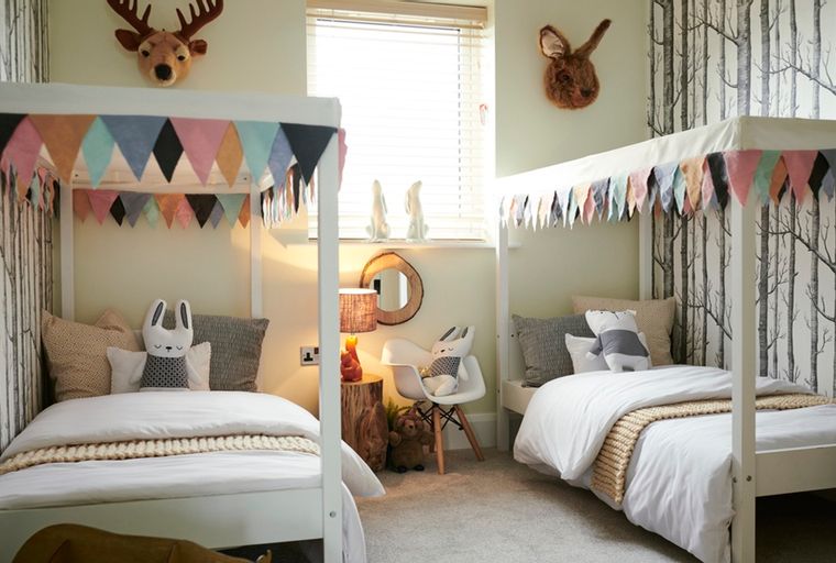 A children's bedroom with two twin beds, decorated with animal motifs and bunting.