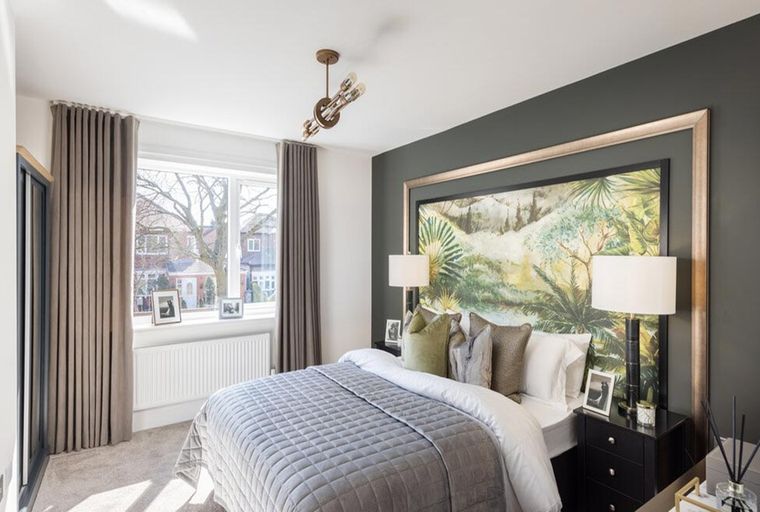 A bedroom with a bed, bedside tables, lamps, and a large window with curtains.
