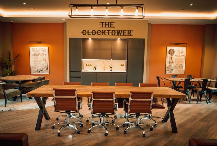 A conference room with a large wooden table and chairs.