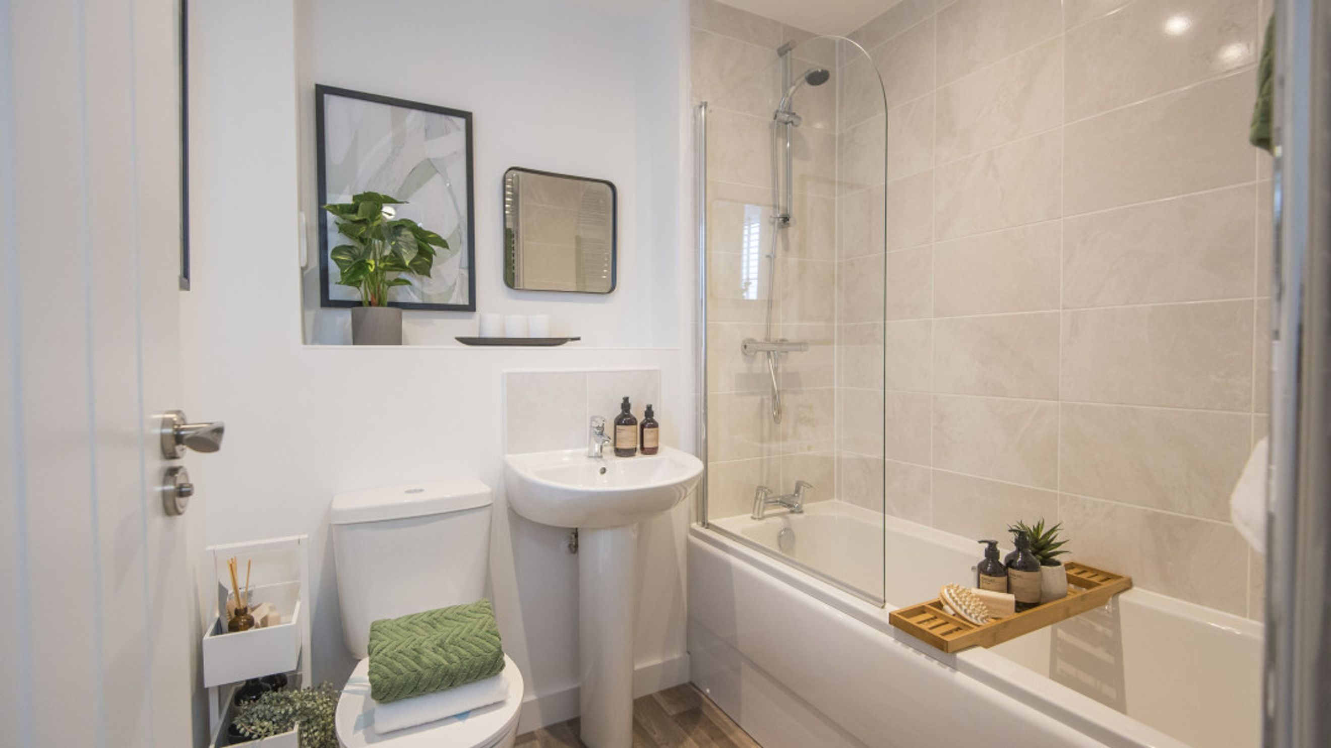 A bathroom with a toilet, sink, and bathtub with a shower.