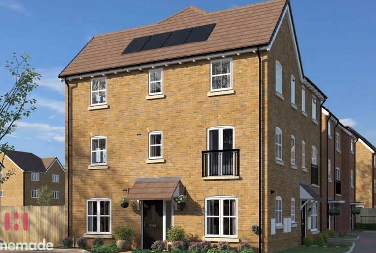 A new build townhouse with yellow brick exterior, solar panels on the roof, and white-framed windows.