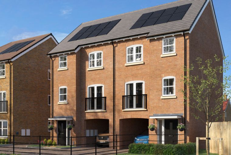 A row of modern brick townhouses with solar panels on the roof and balconies.